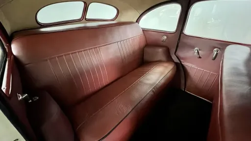 Maroon red leather rear bench seat inside cream 1937 Hudson Terraplane vintage wedding car.