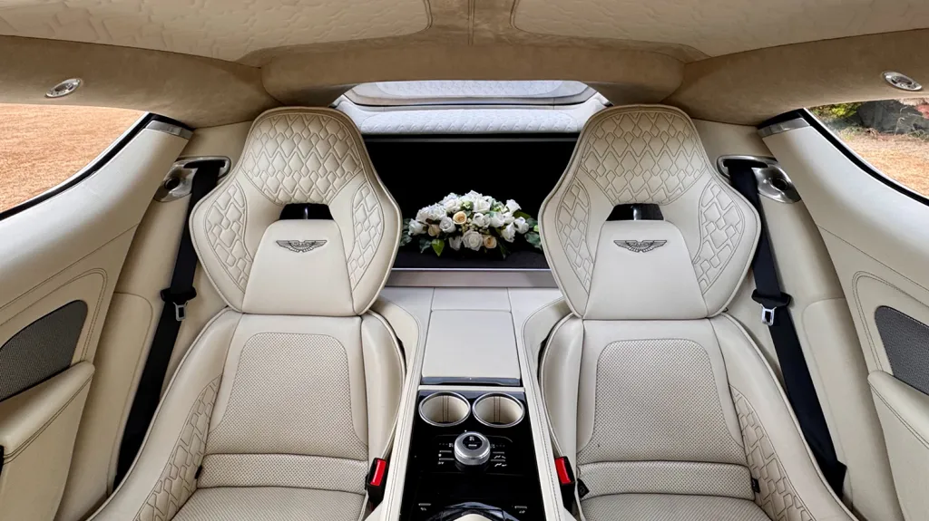 Quilted cream leather rear passenger seats inside Aston Martin Rapide S with individual seating and centre armrest.