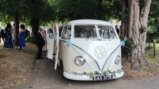 Cream and WHite classic campervan parked outside a wedding venue in Essex with Guests in the background