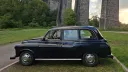 Left side view of classic black taxi cab parked beside Porthkerry Viaduct near Barry, South Wales.