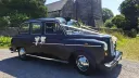 Classic black taxi cab with wedding ribbons parked outside a church in Barry, South Wales.