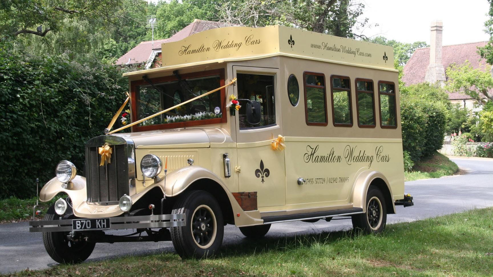 Cream and gold Asquith Mascot 8-seater vintage wedding bus parked in a garden setting