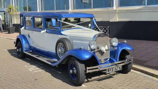 Front three-quarter view of the blue and white Bramwith Landaulette wedding car available for hire in Hampshire
