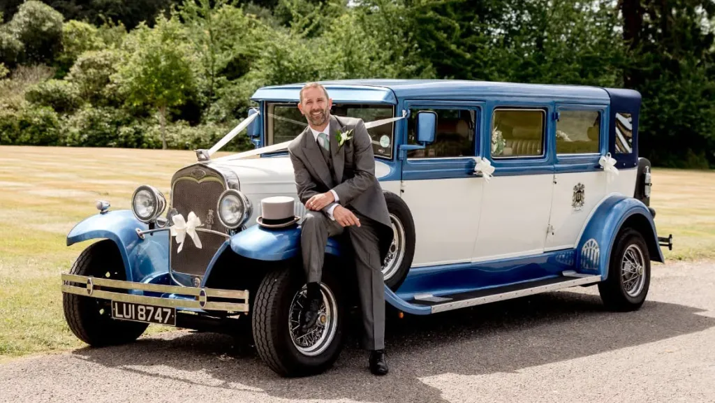 Blue and white Bramwith Landaulette vintage wedding car pictured with the groom