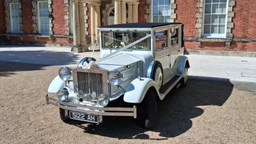 Front view of the white Imperial Viscount Landaulette decorated with wedding ribbons