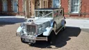 Front view of the white Imperial Viscount Landaulette decorated with wedding ribbons