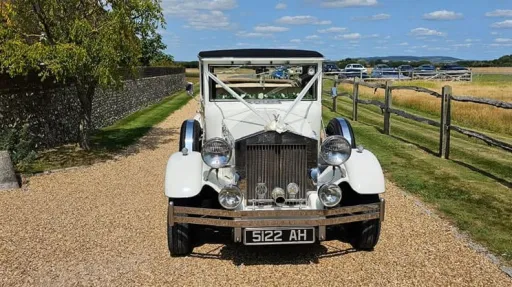 Full front view of the white Imperial Viscount 7-passenger wedding car with wedding ribbons