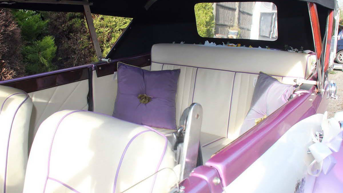 White leather interior of the two-tone lilac and white four-door Beauford Convertible wedding car