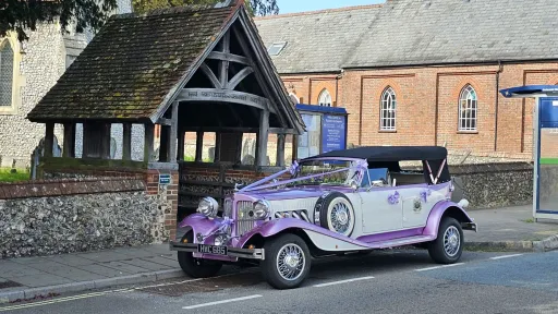 Two-tone lilac and white four-door Beauford Convertible wedding car parked outside a church in Waterlooville