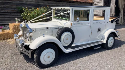 Left side view of the white Imperial Viscount wedding car showing its side-mounted spare wheels