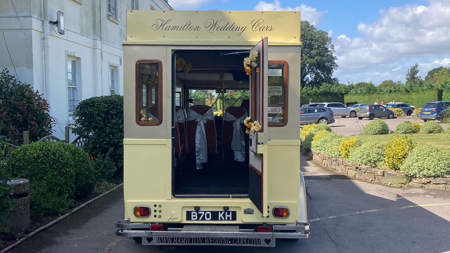 Rear view of the cream and gold Asquith Mascot vintage wedding bus with passenger door open