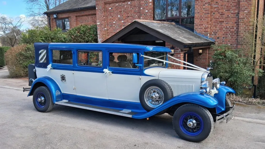 Right side view of the blue and white Bramwith Landaulette parked outside a church in Waterlooville