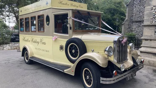 Front three-quarter view of the cream and gold Asquith Mascot 8-passenger wedding bus