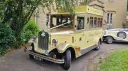 Cream and gold Asquith Mascot vintage wedding bus photographed on a country driveway