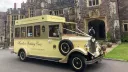 Cream and gold Asquith Mascot vintage wedding bus parked outside Rhinefield House in the New Forest
