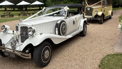 White vintage Beauford Convertible wedding car with dark green interior arriving for wedding duties