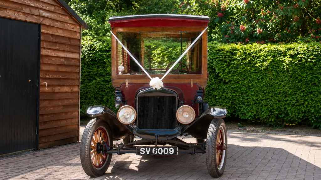 Front view of 1914 Ford Model T Charabanc with white wedding ribbons and bows