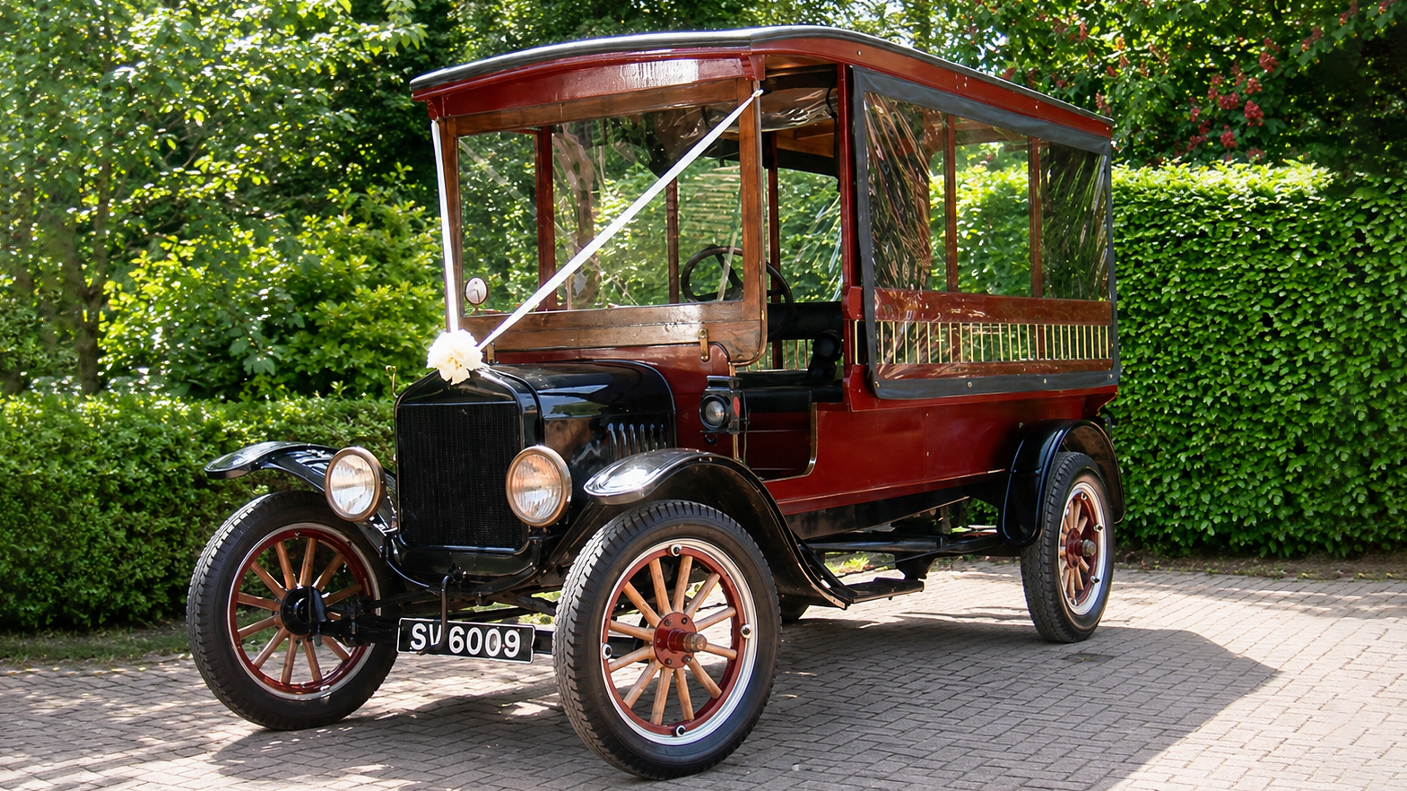 Front three-quarter view of 1914 Ford Model T Charabanc decorated with wedding ribbons