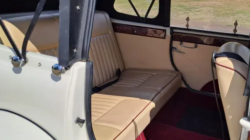 Rear interior of Old English White four door Beauford Convertible with cream leather seating and Burgundy carpet