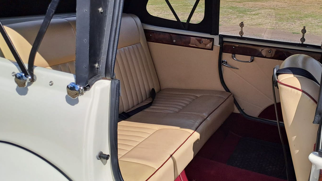 Rear interior of Old English White four door Beauford Convertible with cream leather seating and Burgundy carpet
