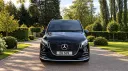 Front view of black Mercedes V-Class Landjets luxury wedding transport in a park