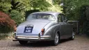 Silver classic Jaguar Mk2 viewed from the rear right on a gravel driveway