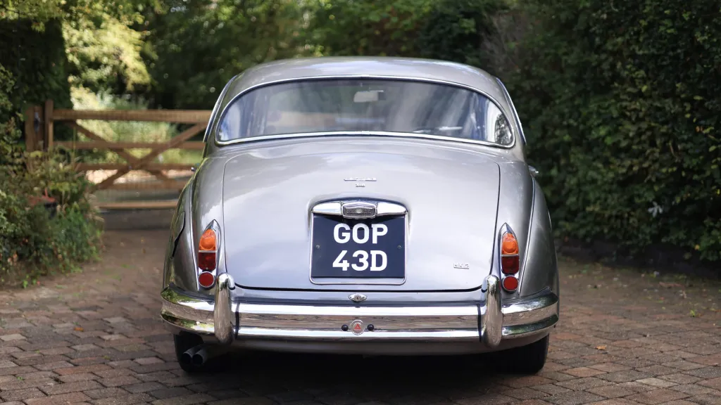 Rear view of a silver classic Jaguar Mk2 with chrome bumpers