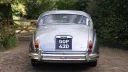 Rear view of a silver classic Jaguar Mk2 with chrome bumpers