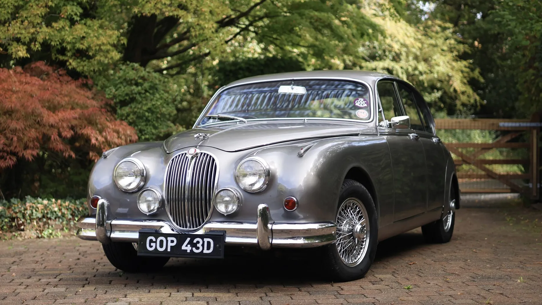 Front three-quarter view of a silver classic Jaguar Mk2 wedding car with chrome grille and wire wheels