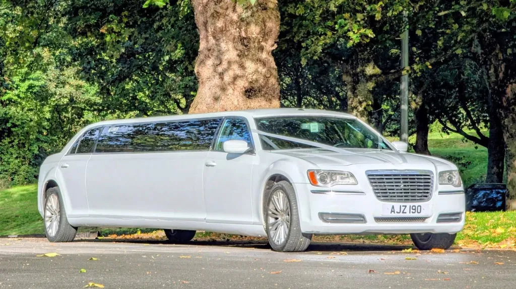 Front right side view white chrysler limousine with privacy windows