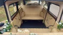 Bramwith Landaulette interior with cream leather bench seats, dark blue carpeting and wood door trim.