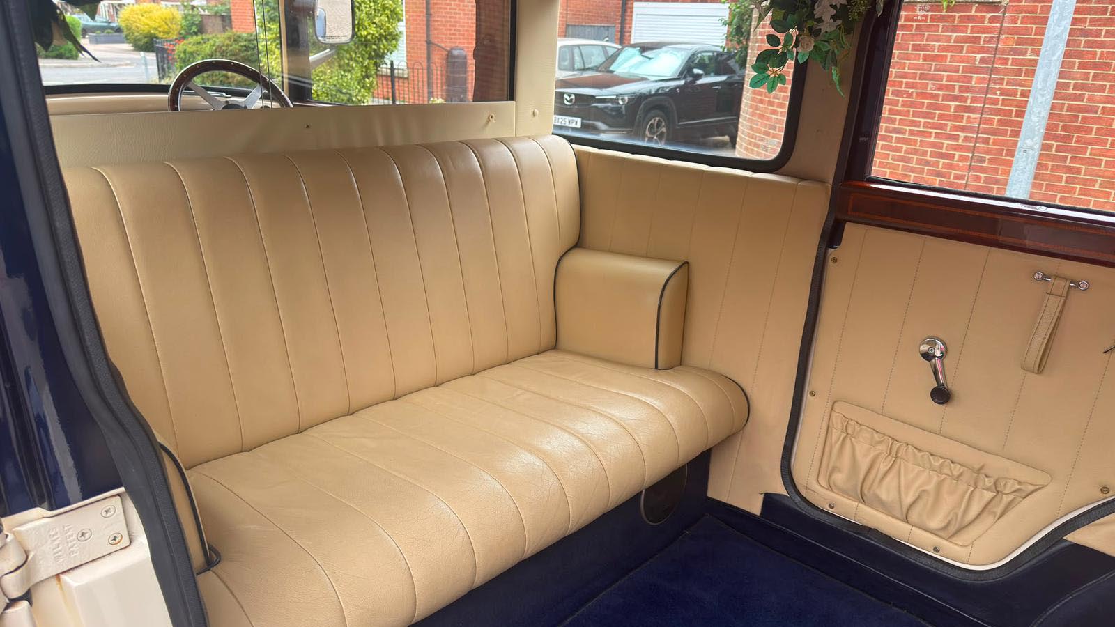 Cream leather passenger seating inside the Bramwith Landaulette wedding car.