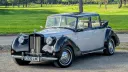 Front three-quarter view of an ivory and black Royale Windsor Landaulette with the rear roof open.
