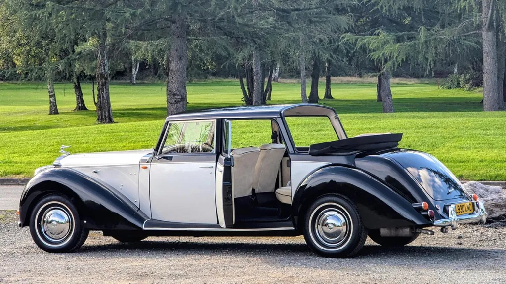 Ivory and black Royale Windsor Landaulette with its passenger door open, showing cream seating and a running board.