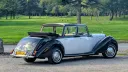 Rear three-quarter view of an ivory and black Royale Windsor Landaulette with its rear roof lowered.