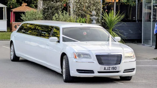 White Stretched Chrysler Limousine with white wedding ribbons
