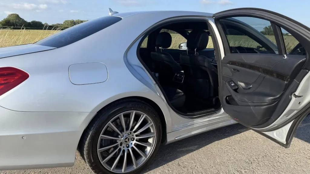 Silver Mercedes S-Class with the rear passenger door open, showing access to the rear seats