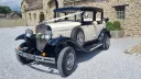 Cream and black Badsworth Landaulette with white wedding ribbons at The Tithe Barn, Bolton Abbey