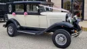 Side view of a cream and black Badsworth wedding car with pink bows at Halo Mansion