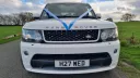Front view of a white Range Rover Sport Autobiography with blue wedding ribbons