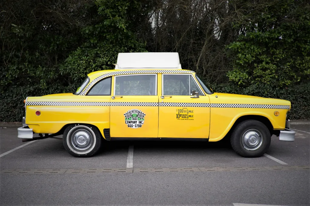 Side view of classic American Yellow Cab with the advertising taxi sign on top of its roof