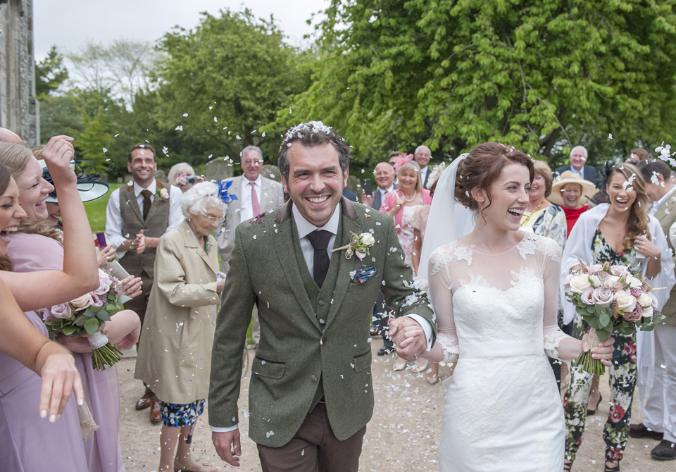 Bride and Groom walking in the middle of their wedding guests throwing confettis