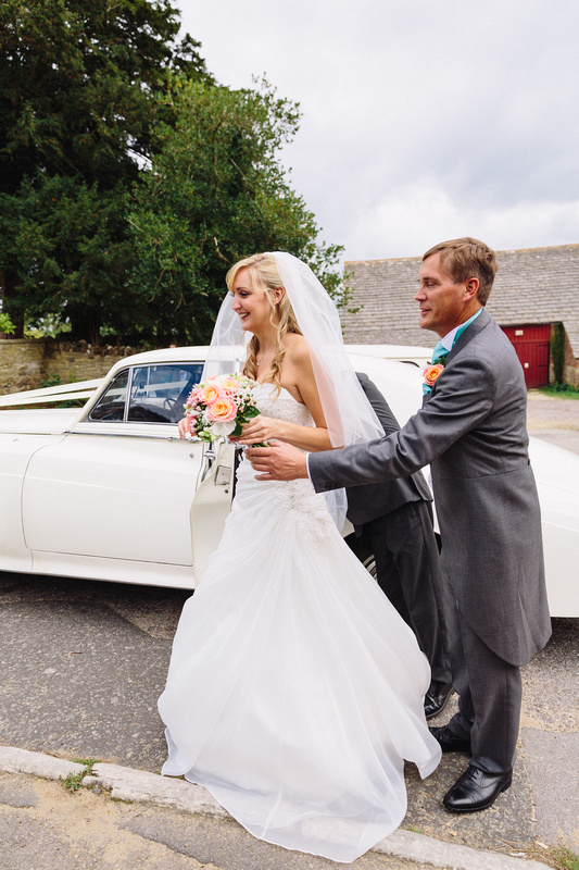 Groom helping the bride exiting the classic rolls-royce