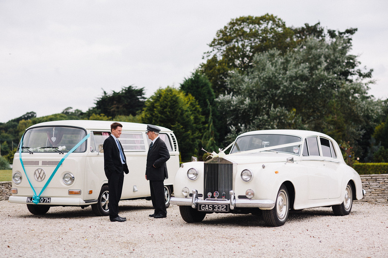Two wedding chauffeurs standing by their vehicles