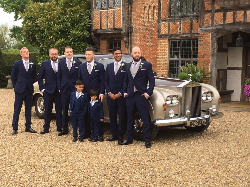 Classic Rolls-Royce Phantom Limousine in Champagne Gold with Groom and Ushers posing for photos around the vehicle