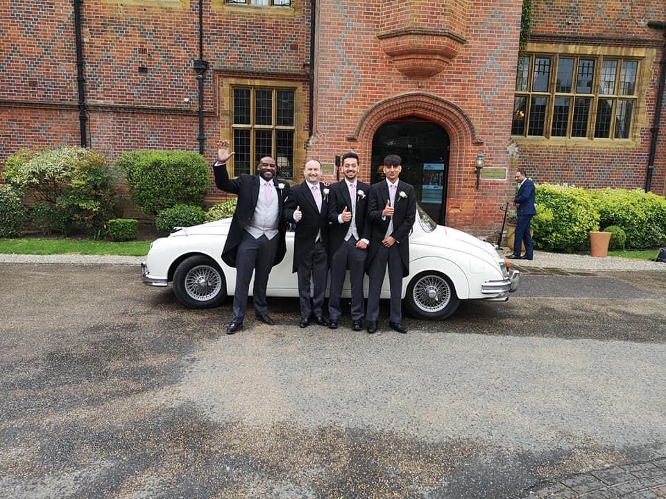 white Mk2 Jaguar with happy Groomsmen in front of the vehicles smiling