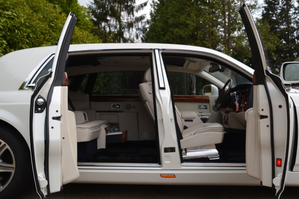 Front driver door and rear passengers rear-hinged door open to show large leg room at the rear, cream leather interior and luxurious interior
