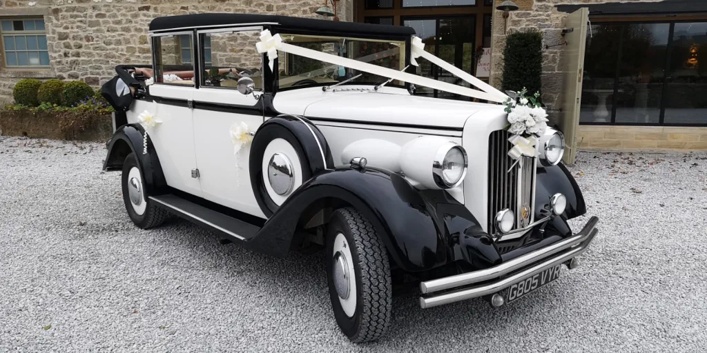 Black & Ivory Regent car with roof down and decorated with white ribbons