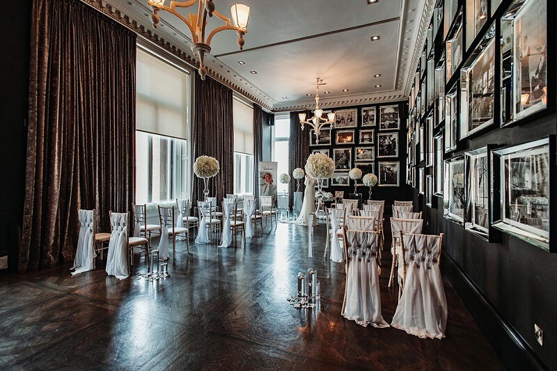 Emply Cermeony room with antique chairs, high ceiling and many photo frames decorating the walls