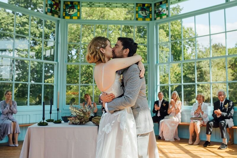 Bride and Groom kissing in front of their wedding guests